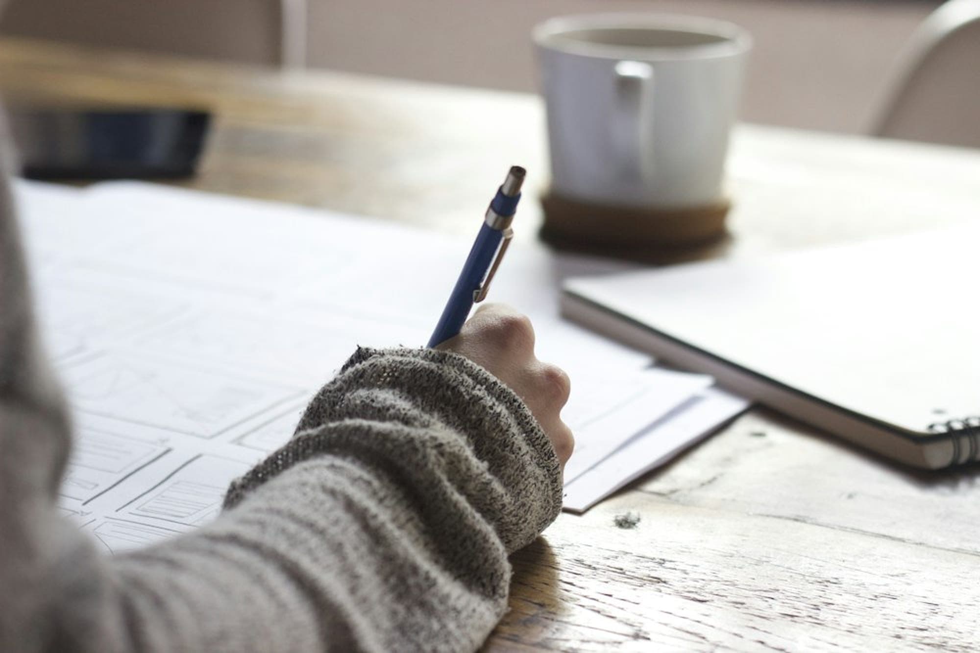 Hand mit Stift über einem Rechenheft